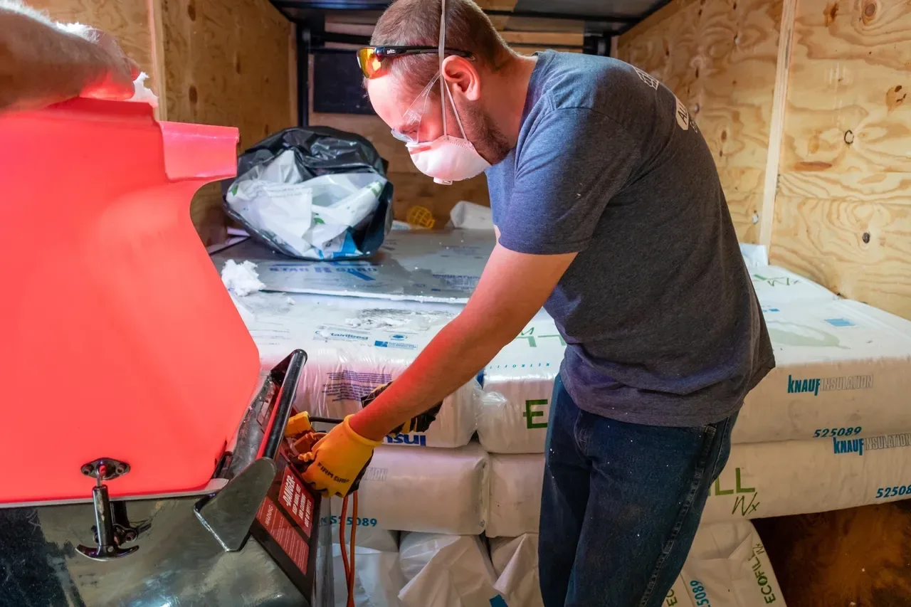 All Out Insulation crew member preparing insulation material on site